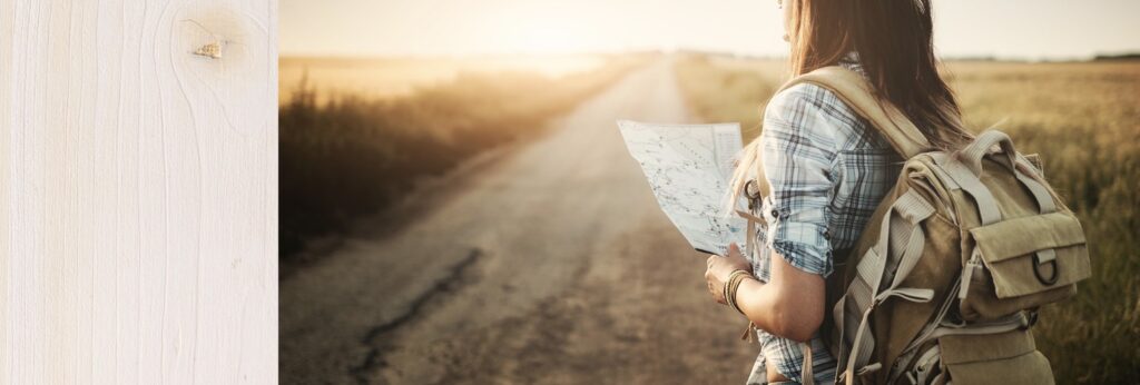 girl looking at a map on a lit road. She's alone, not knowing where she's going